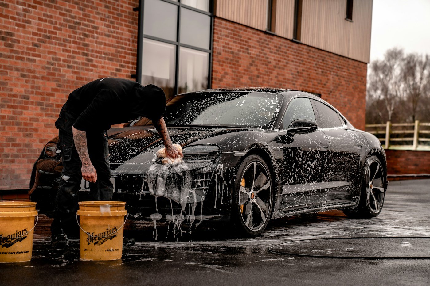 Car being carefully hand washed with a foam mitt